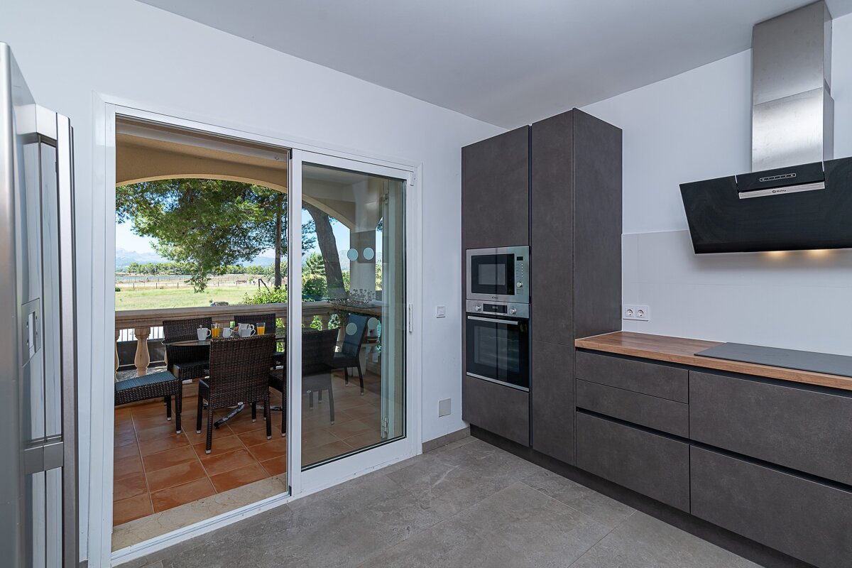 A kitchen with a sliding glass door leading to a balcony
