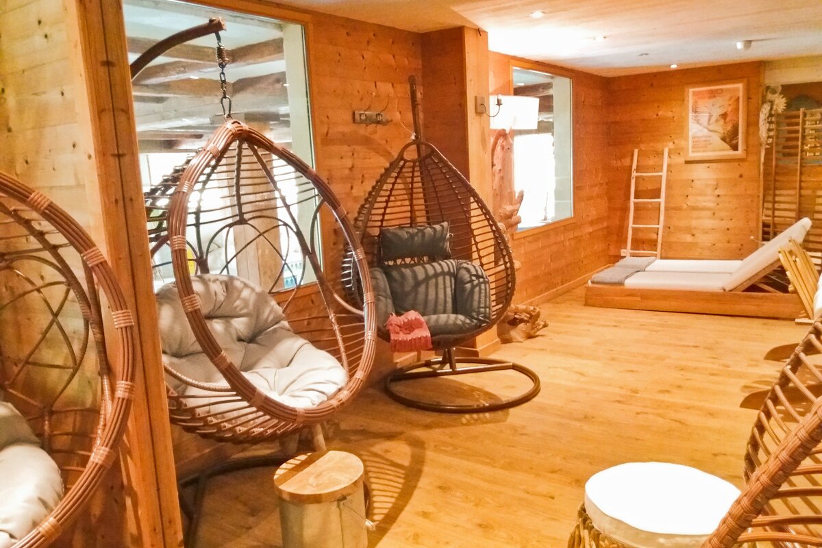 A wooden room with hanging chairs and a ladder