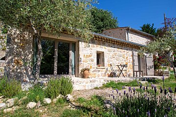 A stone building with a table and chairs outside