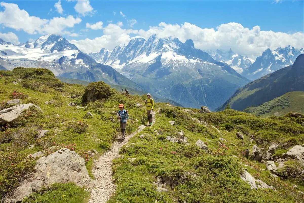 Two people hiking in the mountains with mountains in the background