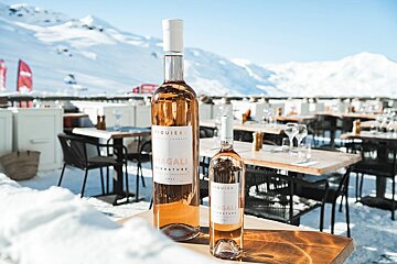 Two bottles of bagali wine sit on a table in the snow