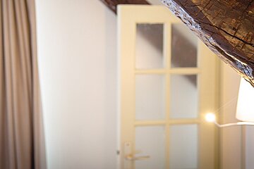 A white door with a wooden beams behind it