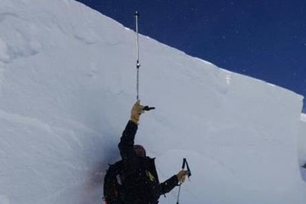 a man standing next to a slab of snow