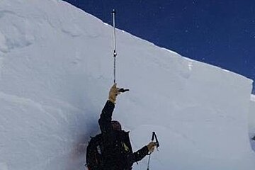 a man standing next to a slab of snow