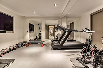 A home gym with a treadmill and a bike