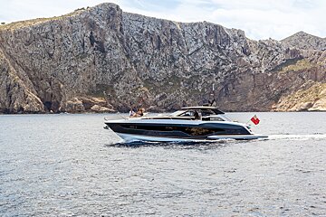 A boat in the ocean with a mountain in the background