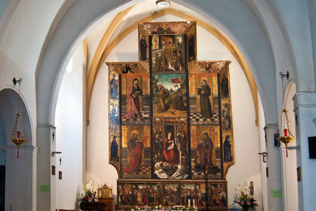 The inside of a church with a large painting on the wall
