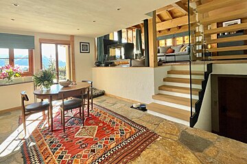 A dining room with a table and chairs and a rug