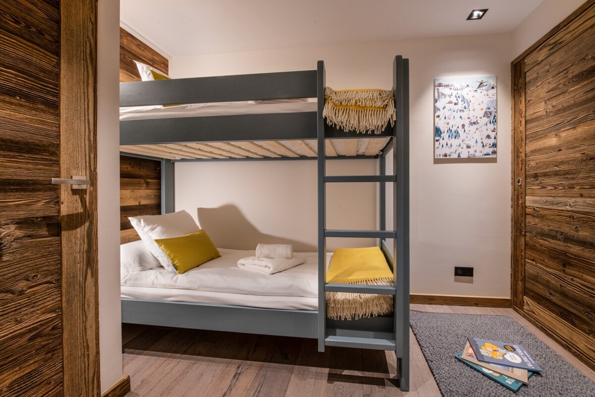A bunk bed in a room with a painting on the wall above it