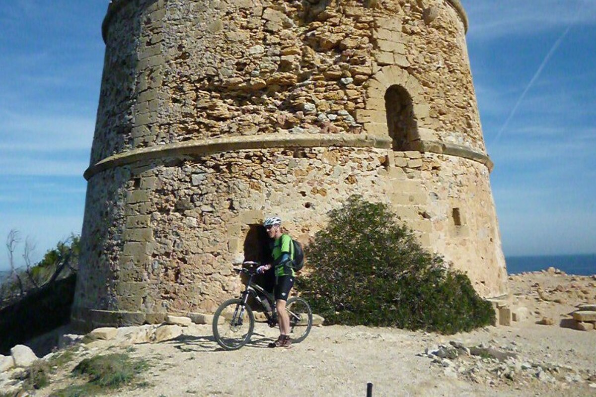 a mountain biker next to a watch tower in mallorca