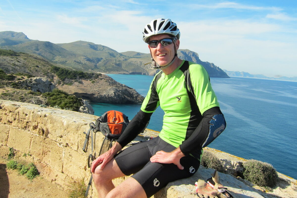 a man in lycra shorts on a wall in mallorca