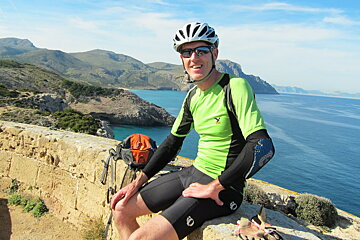 a man in lycra shorts on a wall in mallorca