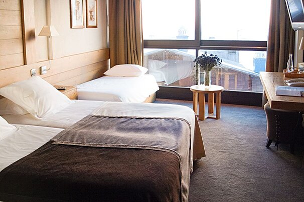 A hotel room with two beds and a desk