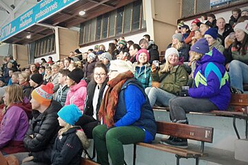 brightly coloured crowd in the bleachers