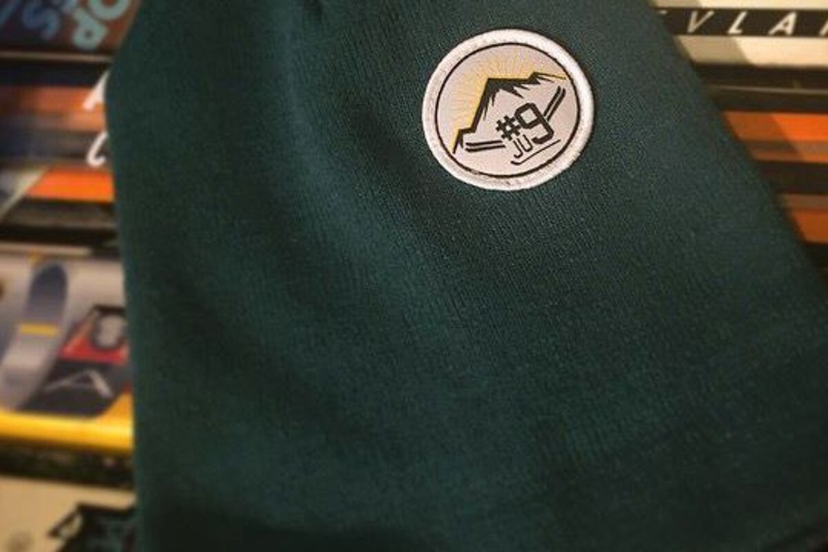 green beanie with a patch on it