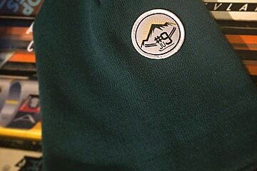 green beanie with a patch on it