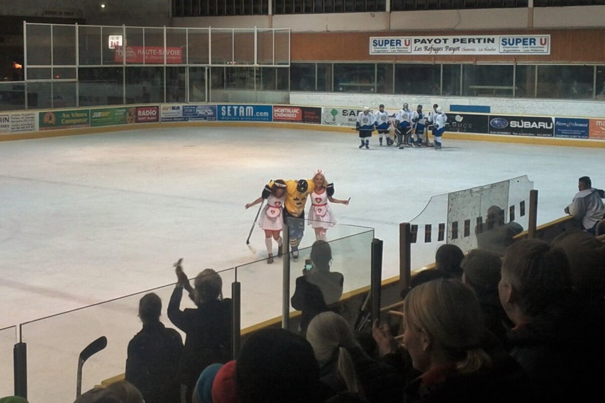2 girls in nurses outfits help an ice hockey player off the ice