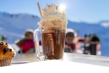 A cup of coffee with whipped cream and the word follie on it