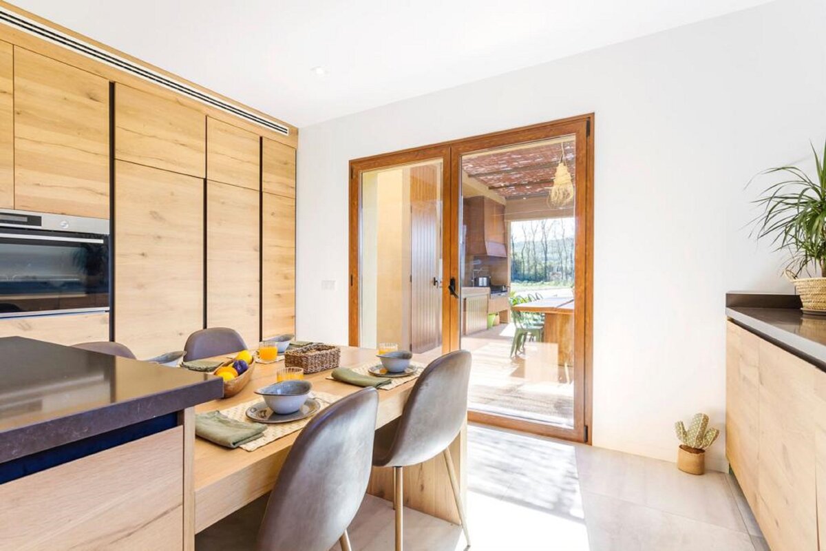 A kitchen with wooden cabinets and a sliding glass door