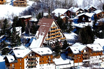 An aerial view of a ski resort with snow on the buildings