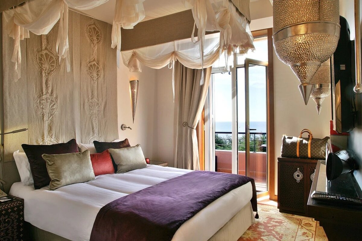 A bedroom with a canopy bed and a view of the ocean