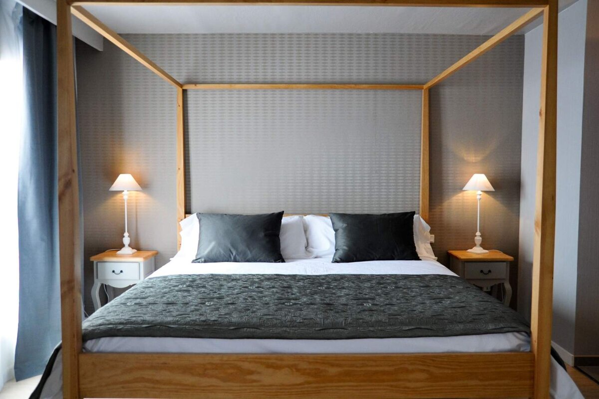 A bedroom with a four poster bed and two nightstands