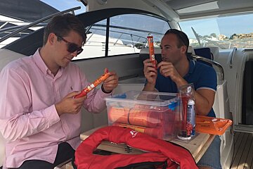 two men examining flares on a yacht in port adriano mallorca