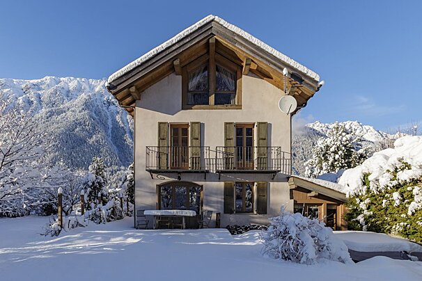 A snowy house with a satellite dish on the roof