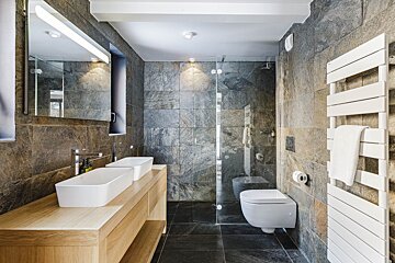 A bathroom with two sinks and a toilet