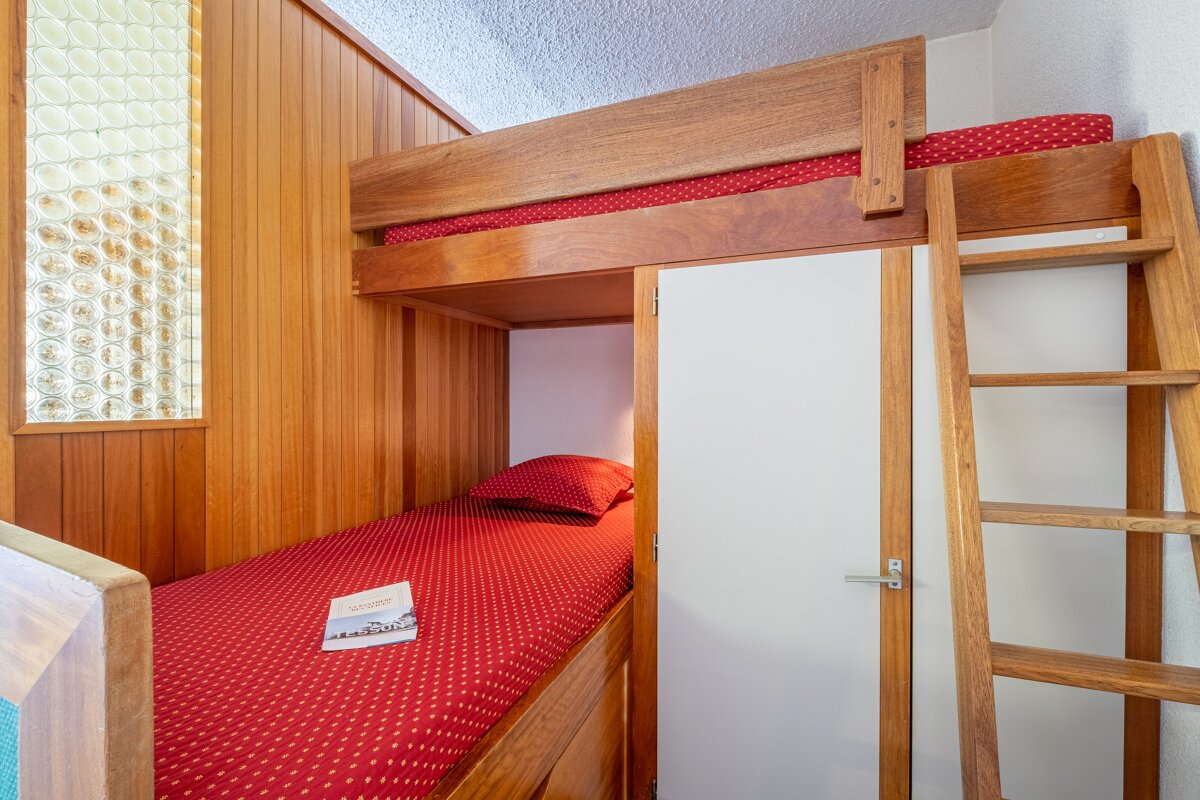 A bunk bed with a red polka dot blanket and a book on it