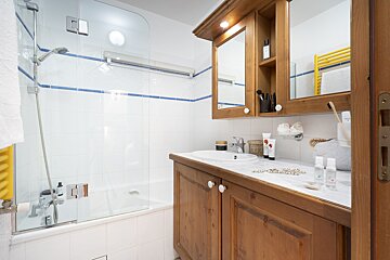 A bathroom with a sink a mirror and a bathtub