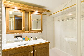 A bathroom with a sink and two mirrors