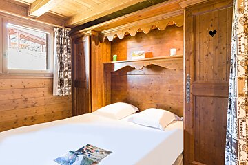 A wooden bedroom with a bed and a window