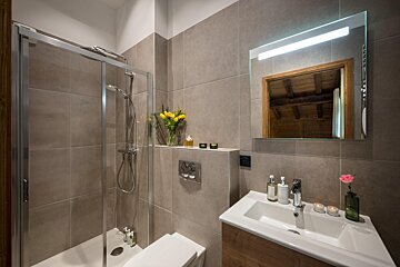 A bathroom with a sink a shower and a mirror