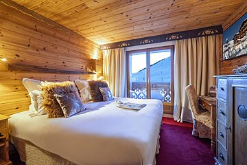 A bedroom with a large bed and a window