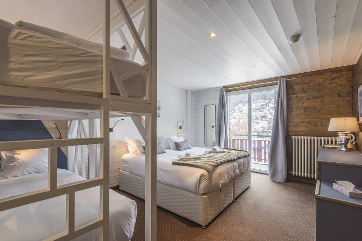 A hotel room with bunk beds and a window