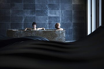 A man and a woman are sitting in a bathtub