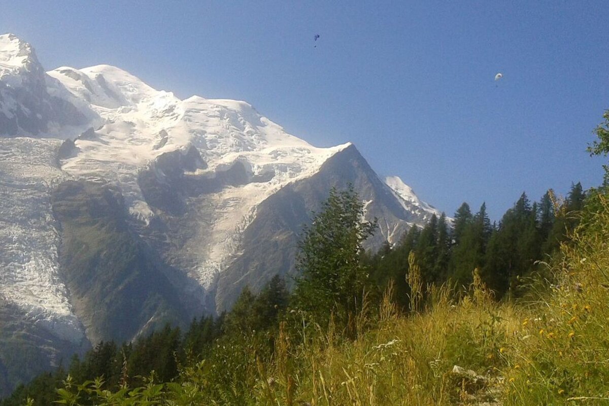Paragliders flying over a hiking trail in Chamonix