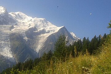 Paragliders flying over a hiking trail in Chamonix
