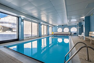 A large indoor swimming pool with a no diving sign