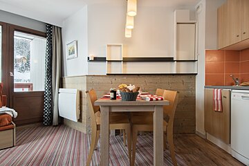 A dining room table with a basket of bread on it