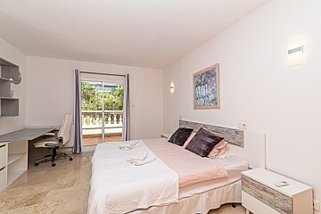 A bedroom with a large bed and a sliding glass door
