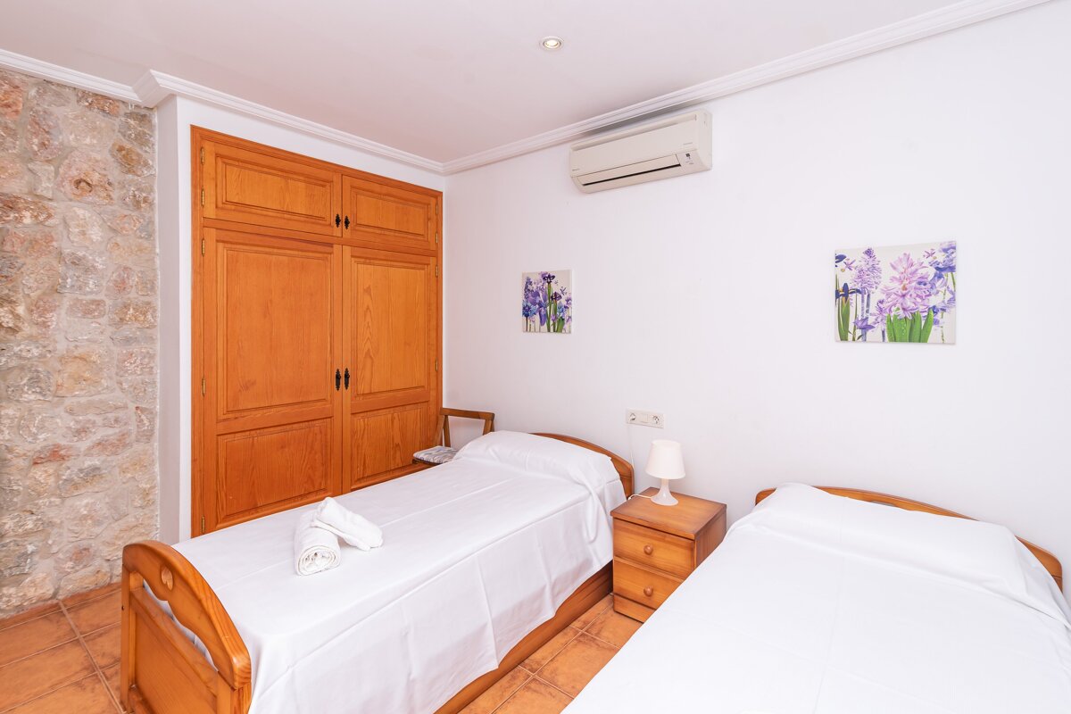 A bedroom with two beds and two paintings on the wall