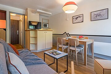 A living room with a couch a table and chairs