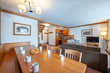 A living room with a dining table and chairs