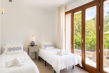 A bedroom with two beds and a large window
