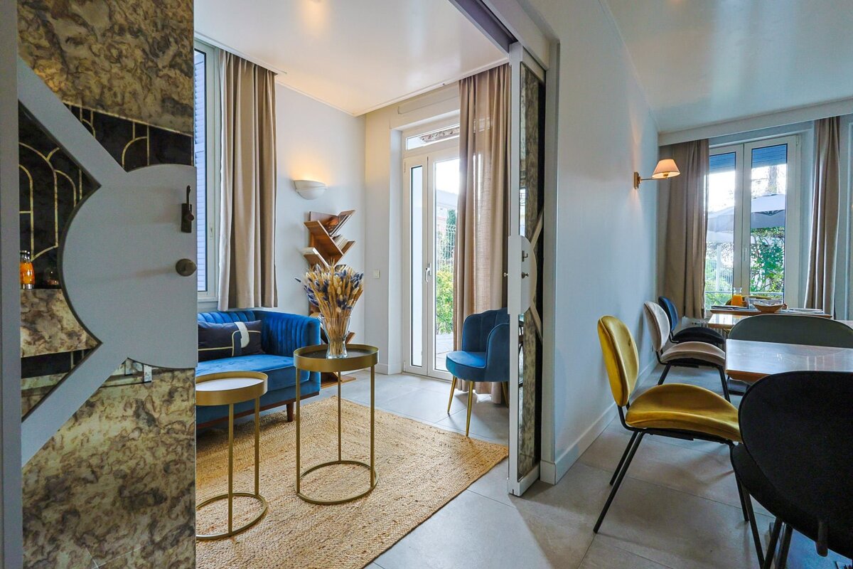 A living room with a blue couch and yellow chairs
