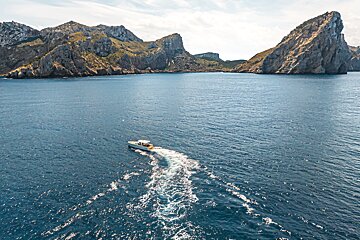A boat in the ocean with mountains in the background