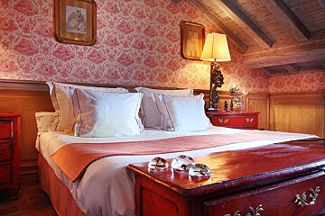 A bedroom with a bed and a red dresser
