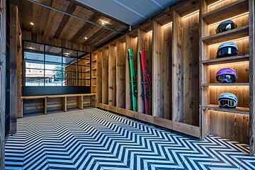 A room with skis and helmets on shelves